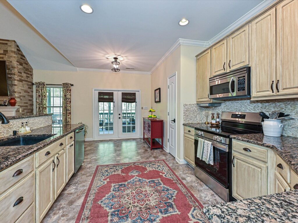 Kitchen with light cabinetry granite countertops and crown molding overlooking great room at 132 Gray Cliff Drive