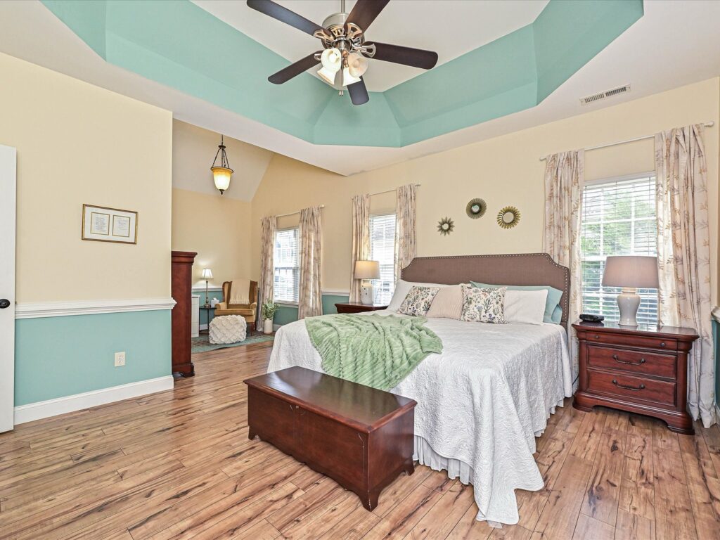 Primary bedroom with tray ceiling chair rail and sitting area with vaulted ceiling at 132 Gray Cliff Drive