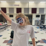 Maddie wearing her Camp Cornelius t-shirt during Olympics Week as a counselor-in-training, with face paint