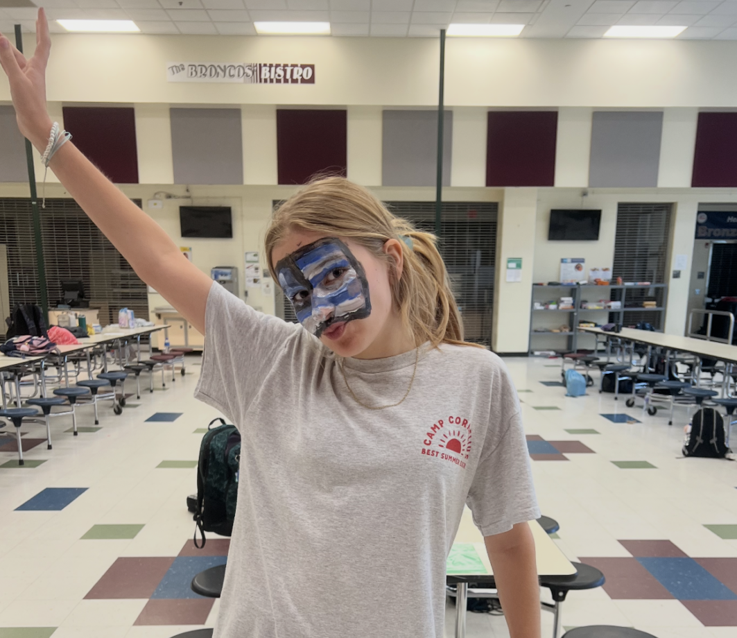 Maddie wearing her Camp Cornelius t-shirt during Olympics Week as a counselor-in-training, with face paint