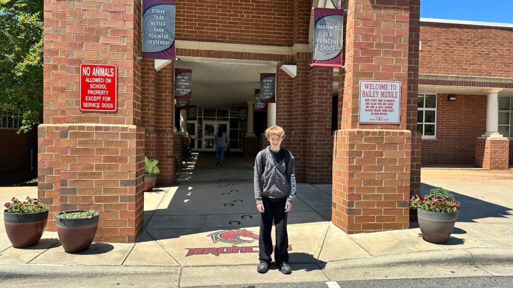 How Bailey Middle School Actually Works Noah Fisher standing in front of the main entrance of Bailey Middle School in Cornelius, North Carolina.