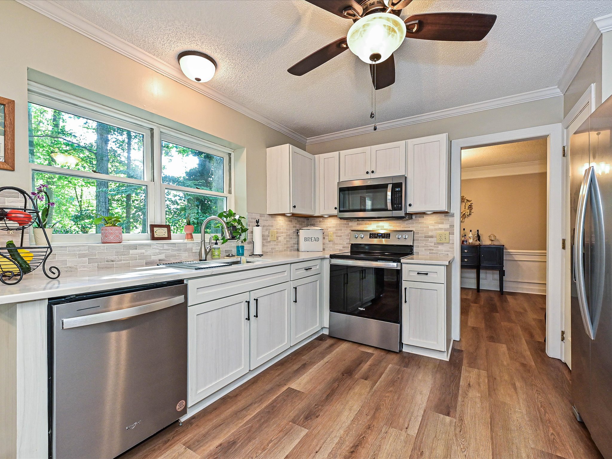 Updated kitchen with white cabinets, quartz countertops, and stainless appliances